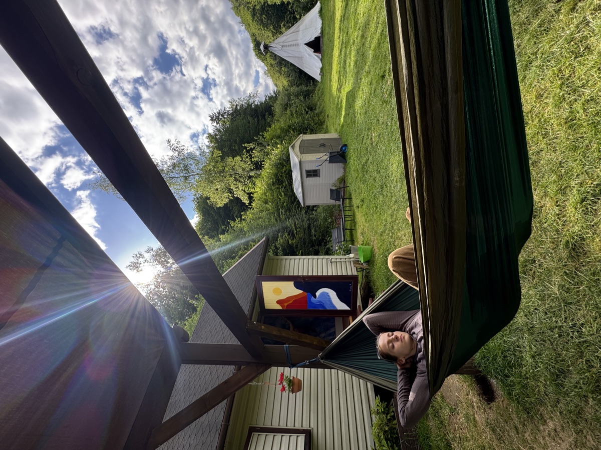 Odpoczynek w hamaku pod altanką z widokiem na zieleń i tipi